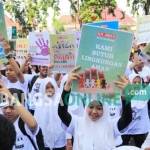 Peserta Gerakan Nasional Anti Kejahatan Seksual pada Anak, mengangkat poster ajakan mewaspadai kejahatan seksual pada anak-anak. foto: yuli iksanti/ BANGSAONLINE