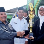 Mbah Tarom menyerahkan piala kepada pemenang lomba HAB. foto: ZAINAL A/ BANGSAONLINE