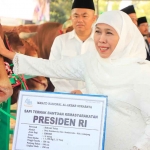 Gubernur Khofifah saat menunjukkan sapi dari Presiden Jokowi di Masjid Nasional Al Akbar Surabaya.