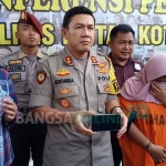 Tersangka (kanan) menutup mukanya saat dirilis oleh Kapolres Blitar Kota AKBP Adewira Negara Siregar, Jumat (31/5/2019).