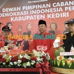 Ketua DPC PDIP Kabupaten Kediri, Murdi Hantoro, saat memotong tumpeng yang selanjutnya diberikan kepada kader senior. Foto: MUJI HARJITA/BANGSAONLINE