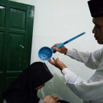 Salah satu siswa ketika disiram dengan air kembang. foto: SYUHUD/ BANGSAONLINE