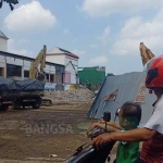 Salah satu warga tengah melihat proses pembongkaran Pasar Legi, Kota Blitar. foto: AKINA/ BANGSAONLINE