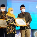 Bupati Gresik Fandi Akhmad Yani (kanan) menerima penghargaan dari Gubernur Jatim Khofifah Indar Parawansa. foto: ist.
