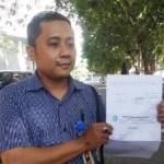 Salah seorang warga, Agus Ariyanto menunjukkan bukti laporan dugaan penggelembungan data siswa penerima dana BOS. (foto: hadi prayitno/BANGSAONLINE)