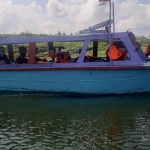Pengunjung wisata sedang keliling Waduk Selorejo menggunakan perahu mesin.

