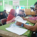 Ketua Pokmas PTSL Kelurahan Gadang, Efendi saat melayani warga yang mengajukan sertifikat program PTSL di aula kantor Kelurahan Gadang, Kamis (30/01). foto: IWAN IRAWAN/ BANGSAONLINE