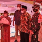 Zainul Arifin, S.S.T.P. (kanan), saat mendampingi Bupati Gus Yani menyerahkan bantuan di Posko Darurat Kebomas. (foto: SYUHUD/ BANGSAONLINE)