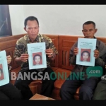 Bapak korban bersama kepala desa memperlihatkan foto korban. foto: GUNAWAN/ BANGSAONLINE