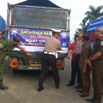 Simulasi penempelan imbauan tertib lalu lintas di belakang truk.