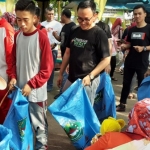 Bupati Pamekasan Baddrut Tamam (kaos hitam berkaca mata) saat memungut sampah di area  Car Free Day (CFD) Taman Monumen Arek Lancor.