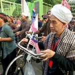 Salah satu peserta dari negara tetangga (Malaysia) tampak sedang menuntun sepeda onthelnya. 
