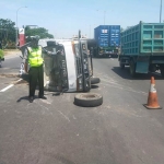 Truk boks nopol L 9085 BH yang terguling di Jalan Tol Kilometer 753.800. (foto: ist).