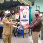 Petugas Dinsos Kota Kediri saat menyalurkan bantuan di Kelurahan Setonopande, Kecamatan Kota. foto: ist.