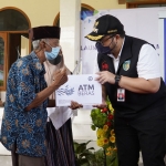 Bupati Kediri Hanindhito Himawan Pramana saat menyerahkan ATM Beras kepada salah satu warga penerima manfaat, Muji Martoyo, warga Dusun Krajan, Desa Mangunrejo. foto: ist.