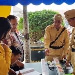 Beberapa polisi berbusana perjuangan tampak sedang melayani masyarakat.