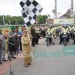 Bupati Jombang, Nyono Suharli, dan Wabup Jombang Munjidah Wahab (bawa bendera) saat memberangkatkan rombongan tiga pilar. foto: rony suhartomo/ BANGSAONLINE