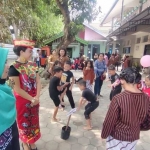 Wakil Kepala SD Emaus Bidang Kurikulum Ana Ribudi Ningsih (berpakaian adat) bersama Eri (berjilbab) dari Kementerian Pendidikan saat melihat anak-anak yang sedang bermain lompat tali. Foto: MUJI HARJITA/ BANGSAONLINE.com