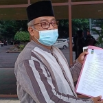Drs. H. Masykur Lukman saat menunjukkan surat perjanjian sewa antara dirinya dengan Pemkab Kediri. (Muji Harjita).