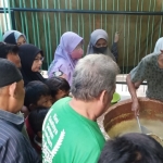 Warga tampak antre untuk mendapatkan satu porsi bubur muhdhor yang sempat menghilang selama dua kali Ramadan ini.