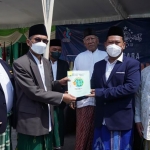 Bupati Gresik Fandi Akhmad Yani (dua dari kanan) didampingi Ketua ATR/ BPN Gresik, Asep Heri menyerahkan sertifikat tanah Bukit Condrodipo kepada Ketua PCNU Gresik KH Khusnan Ali. foto: SYUHUD/ BANGSAONLINE