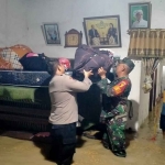 Petugas gabungan saat mengevakuasi barang milik warga yang terendam banjir di Kecamatan Dawarblandong, Kabupaten Mojokerto.