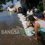 Warga memasang tanggul darurat di atas sungai sengon untuk meminimalisir banjir. foto: rony suhartomo/ BANGSAONLINE