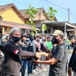 Koordinator EPPI, Benny Prasetya, saat menyerahkan secara simbolis bantuan bibit alpukat kepada Kepala Desa Senden, Mat Jumain, sebelum aksi bersih-bersih sampah di sungai. Foto: MUJI HARJITA/BANGSAONLINE