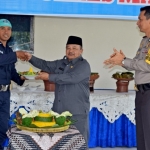 Mbah Tarom saat memberikan potongan tumpeng kepada salah satu perwakilan Satpam.