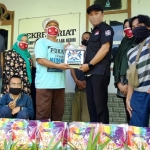 Tomma Rohmad Buana, Ketua Bidang Usaha Kosti Kediri saat menyerahkan bantuan beras kepada pengurus PDKK, Rabu (17/6). (foto: Muji Harjita/ BANGSAONLINE)