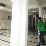 Wasto (baju hijau) saat melakukan bersih-bersih menjelang persiapan ibadah sholat Jumat.
