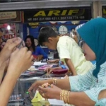 Karyawan toko emas di Lamongan saat melayani pembeli.