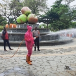 Petugas gabungan saat melakukan penyemprotan disinfektan di Alun-Alun Kota Wisata Batu (KWB).