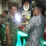 Kasatpol PP Kota Mojokerto Heryana Dodik Murton memberikan penjelasan kepada manajemen salah satu cafe.
