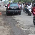 Warga menunjukkan  jalan ambles dan bergelombang,akibat galian pipa PDAM di Desa Sugihwaras, kemarin. foto : khumaidi/BangsaOnline