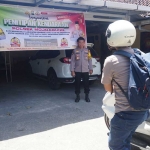 Kapolsek Mojoagung, Kompol Yogas, saat menyambut pemudik yang menitipkan kendaraan.