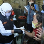 Gubernur Jawa Timur Khofifah Indar Parawansa saat membagikan masker kepada warga Surabaya, Senin (29/6/2020). foto: ist/ bangsaonline.com