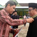 Wali Kota Kediri, Abdullah Abu Bakar (kiri), saat menyerahkan Satya Lencana Karya Satya pertama kepada salah satu ASN Kemenag di wilayahnya. Foto: Ist