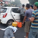 Satu penumpang mobil Toyota Agya tampak tergeletak usai dikeluarkan dari mobil. 