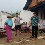 Salah seorang warga korban puting beliung menyelamatkan barang-barangnya.