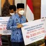 Bupati Arifin menyalurkan secara simbolis dana KUR dari BNI ke petani porang. (foto: HERMAN/ BANGSAONLINE)