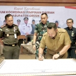 Bupati Gresik saat menandatangani kesepakatan patuhi jam operasional angkutan barang. Foto: Ist