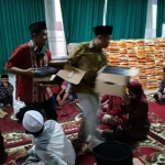 Para relawan penanganan Covid-19 Mojokerto Jawa Timur saat membagikan sarung dan beras sedekah Prof. Dr. KH. Asep Saifuddin Chalim, M.Ag di Guest House kampus Institut KH Abdul Chalim Pacet Mojokerto Jawa Timur, Jumat (15/5/2020). foto: MMA/bangsaonline.com 