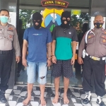 Kedua pelaku saat diapit petugas Unit Reskrim Polsek Rungkut.