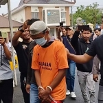 Tersangka saat digiring petugas di Mapolres Pamekasan.