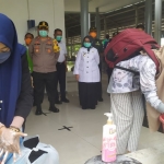 Penumpang di Stasiun KA Jombang diminta cuci tangan terlebih dahulu. foto: AAN AMRULLOH/ BANGSAONLINE