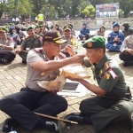 Kapolres Malang Kota AKBP. Asfuri dan Letkol. Inf. Nurul Yakin, saling menyuapi sarapan nasi bungkus (pecel). foto : IWAN/ BANGSAONLINE