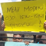Aksi warga saat demo di depan Balai Desa Hargoretno sambil membawa sejumlah poster.
