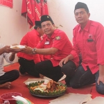 Ketua DPC PDIP Nganjuk Tatit Heru Tjhyono memberikan potongan tompeng kepada tokoh utama pendiri DPC PDIP Nganjuk, Susilo Muslim. foto: BAMBANG/ BANGSAONLINE