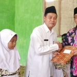 Kepala Kemenag Tuban saat menyerahkan santunan kepada siswa-siswi kurang mampu.